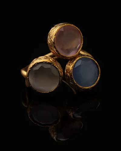 Mauve & Slate - a gold-plated ring with three purple and grey cat eye stones, on black