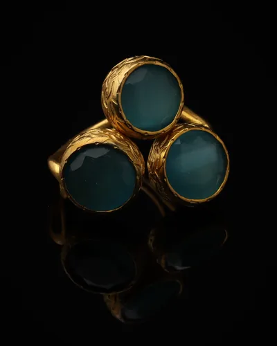 Harbor - a gold-plated ring with three teal and blue cat eye stones, on black