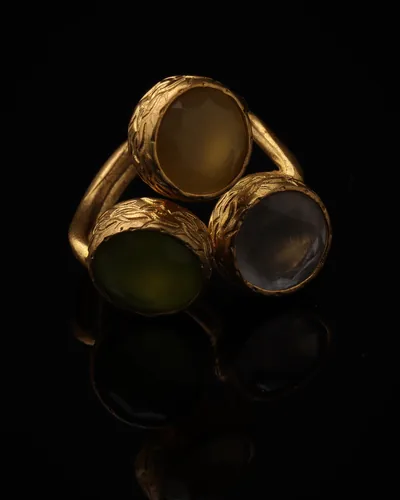 Butterscotch & Thyme - a gold-plated ring with three yellow and olive green cat eye stones, on black