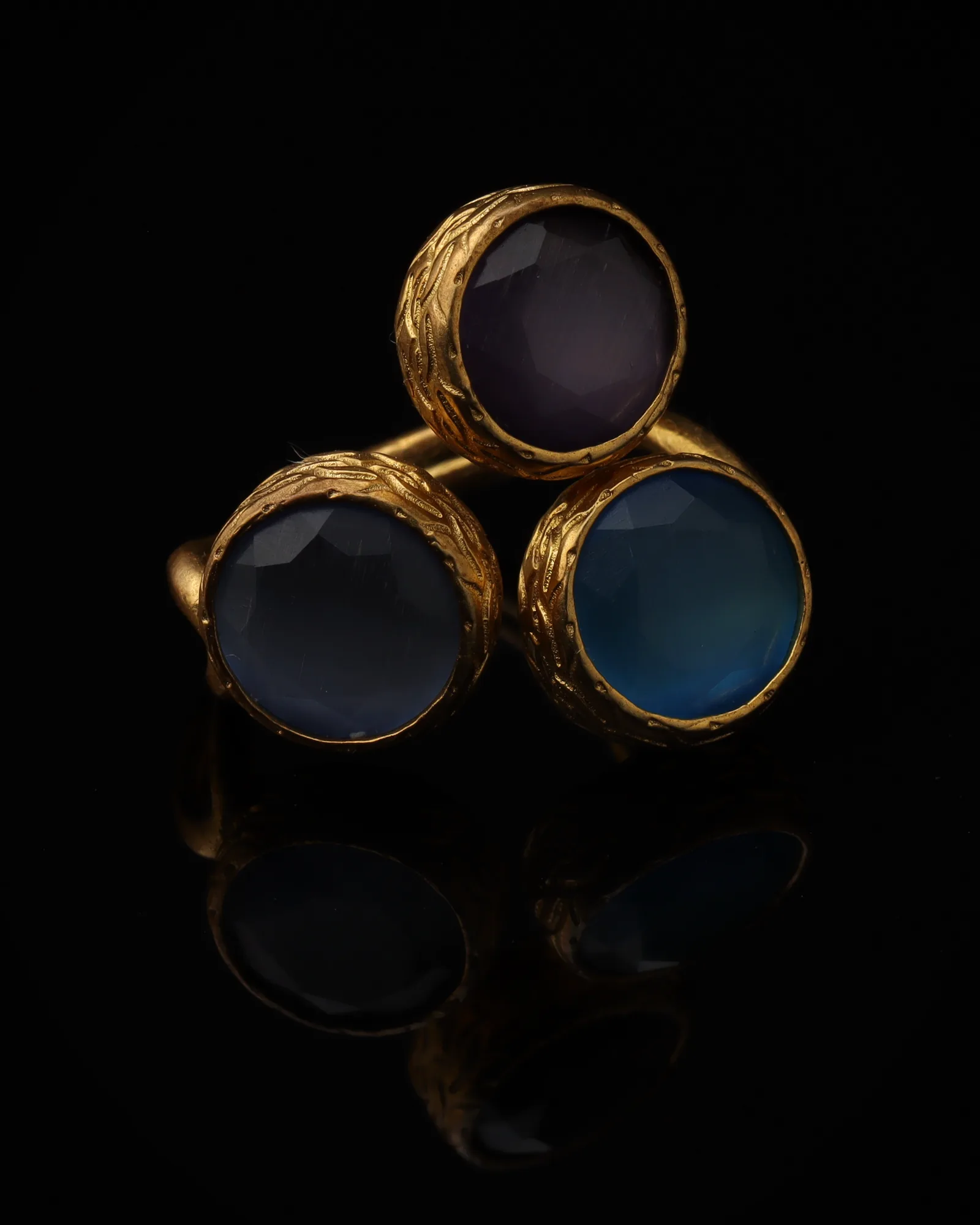 Denim - a gold-plated ring with three blue and navy cat eye stones, on black