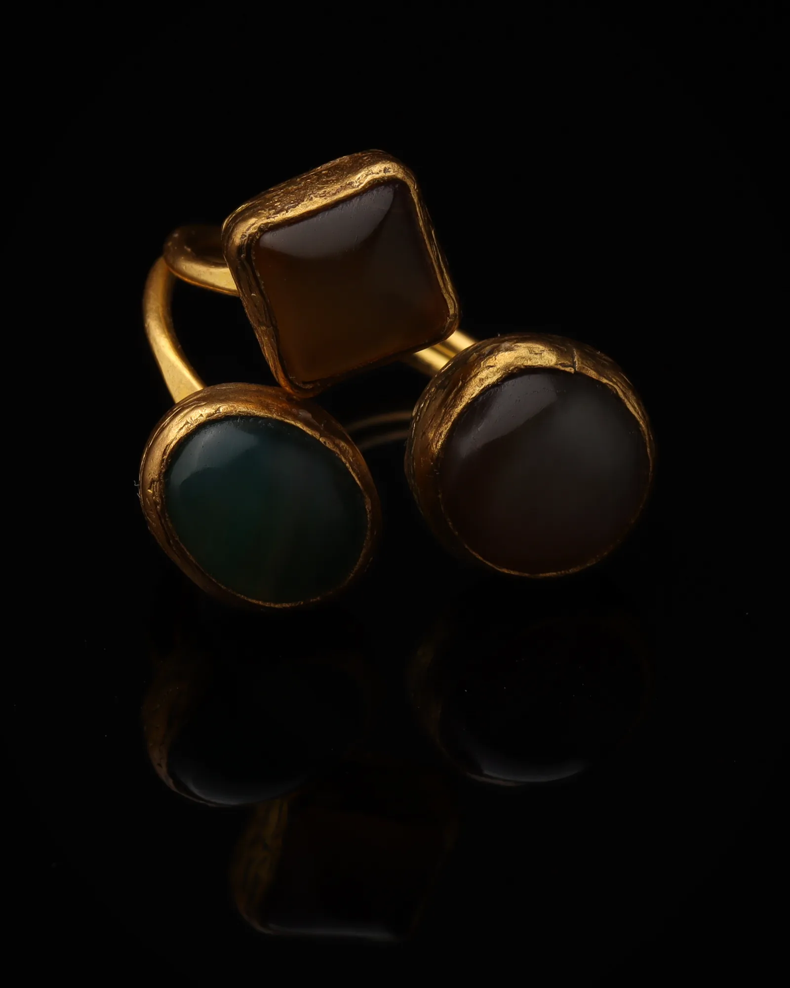 Seafoam & Toffee - a gold-plated ring with three teal and brown cat eye stones, on black