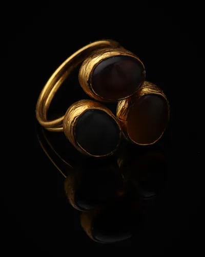 Storm & Sable - a gold-plated ring with three grey and brown cat eye stones, on black