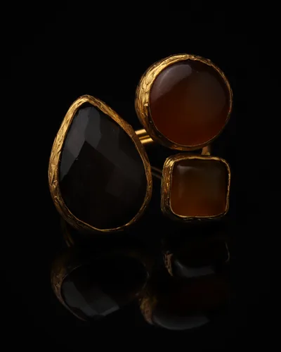 Cocoa & Ginger - a gold-plated ring with three brown and orange cat eye stones, on black