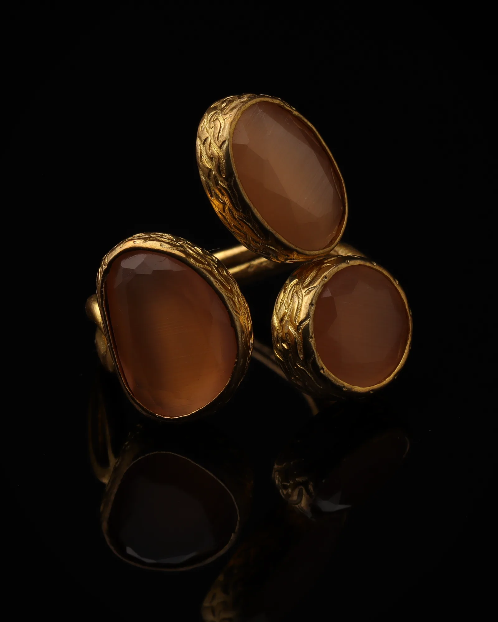Terracotta & Blush - a gold-plated ring with three orange and pink cat eye stones, on black
