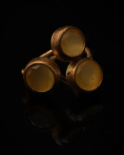 Goldenrod - a gold-plated ring with three yellow and brown cat eye stones, on black