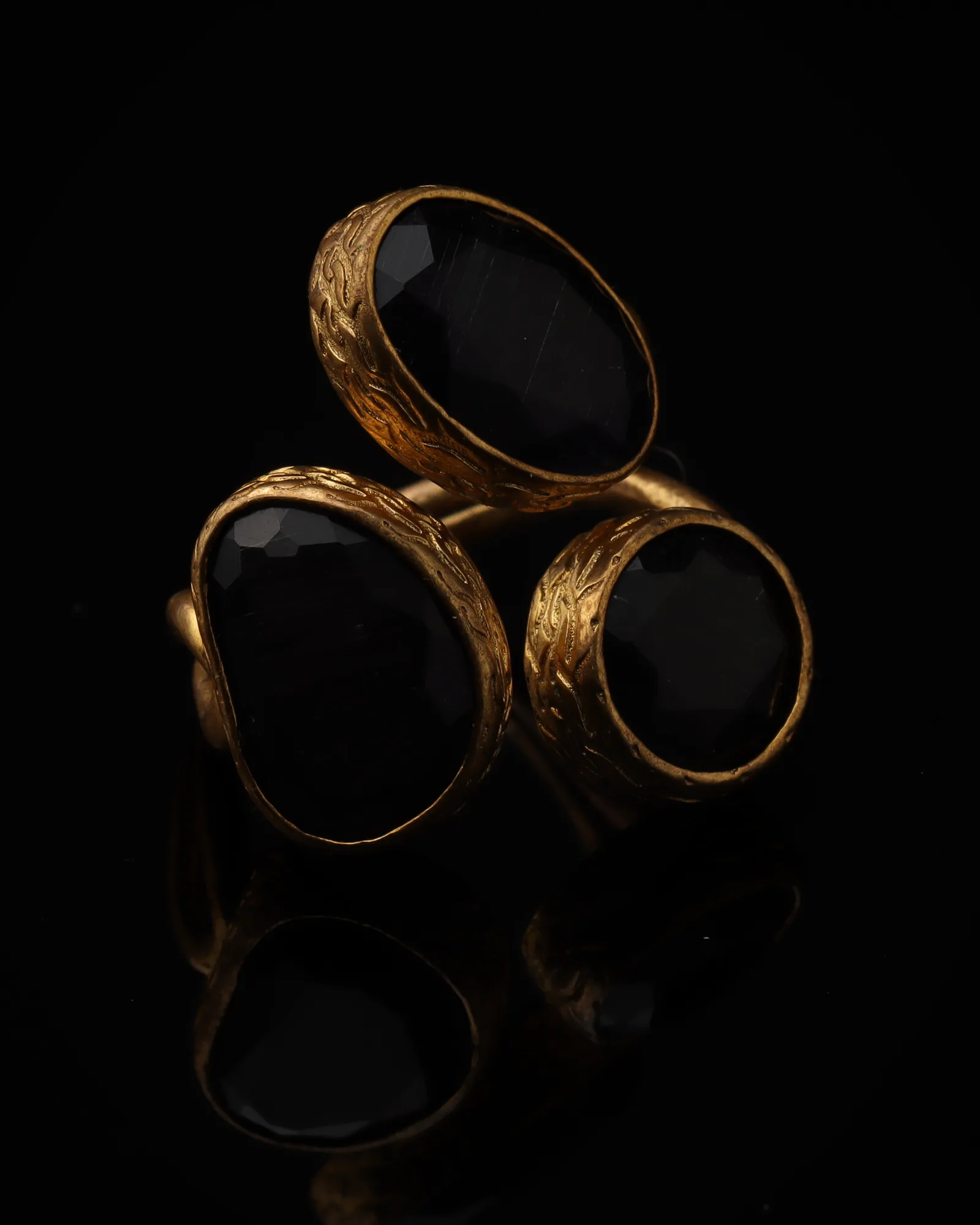 Raven & Honey - a gold-plated ring with three black and yellow cat eye stones, on black
