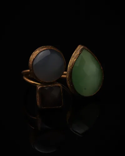 Slate & Fern - a gold-plated ring with three grey and green cat eye stones, on black